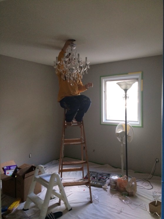 Finally, the room was painted and it was time to move onto the chandelier. I assembled the glitzy number and Marky installed the beast. It was a proud moment... electrical work!