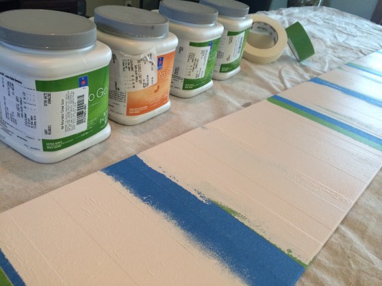 I put different widths of tape on the board and left some wood exposed. Then used a mini roller to paint on one color (2-3 coats). Next, I'll take another "set" of tape off, cover up the first color with tape and roll again. This will continue until all four colors are applied.